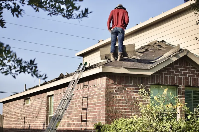 Professional roofer working on a residential roof in Levassor Park